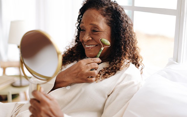 Ältere Frau benutzt einen Jade-Roller für ihr Gesicht